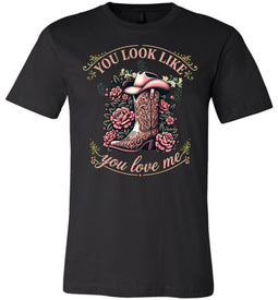 Black t-shirt with a graphic of a cowboy boot and floral design, text 'You look like you love me', on a white background.