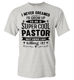 A light heather gray short-sleeve t-shirt with a black graphic text print on the front that reads, 'I NEVER DREAMED I'D GROW UP TO BE A SUPER COOL PASTOR BUT HERE I AM killing it!'.