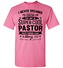 Load image into Gallery viewer, A pink short-sleeve crewneck t-shirt with a black graphic text print on the front that reads 'I NEVER DREAMED I'D GROW UP TO BE A SUPER COOL PASTOR BUT HERE I AM killing it!'.