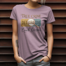 Load image into Gallery viewer, Person wearing a purple t-shirt with 'True Crime Detective Couch Division' text and graphic.